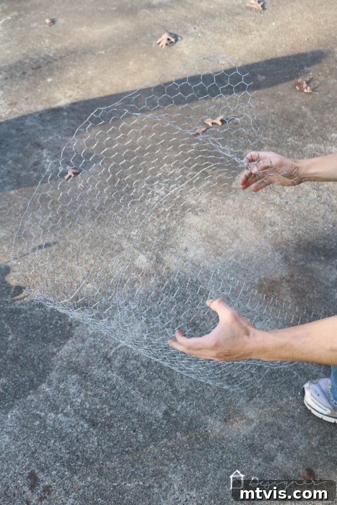 Gloves on, cut chicken wire rectangles twice as long as wide for DIY lighted Christmas balls.