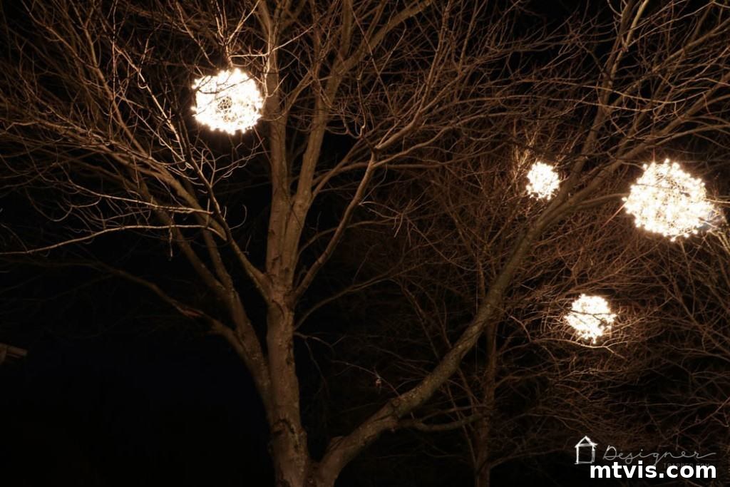 Front yard illuminated by a collection of DIY lighted Christmas balls, creating a winter wonderland.