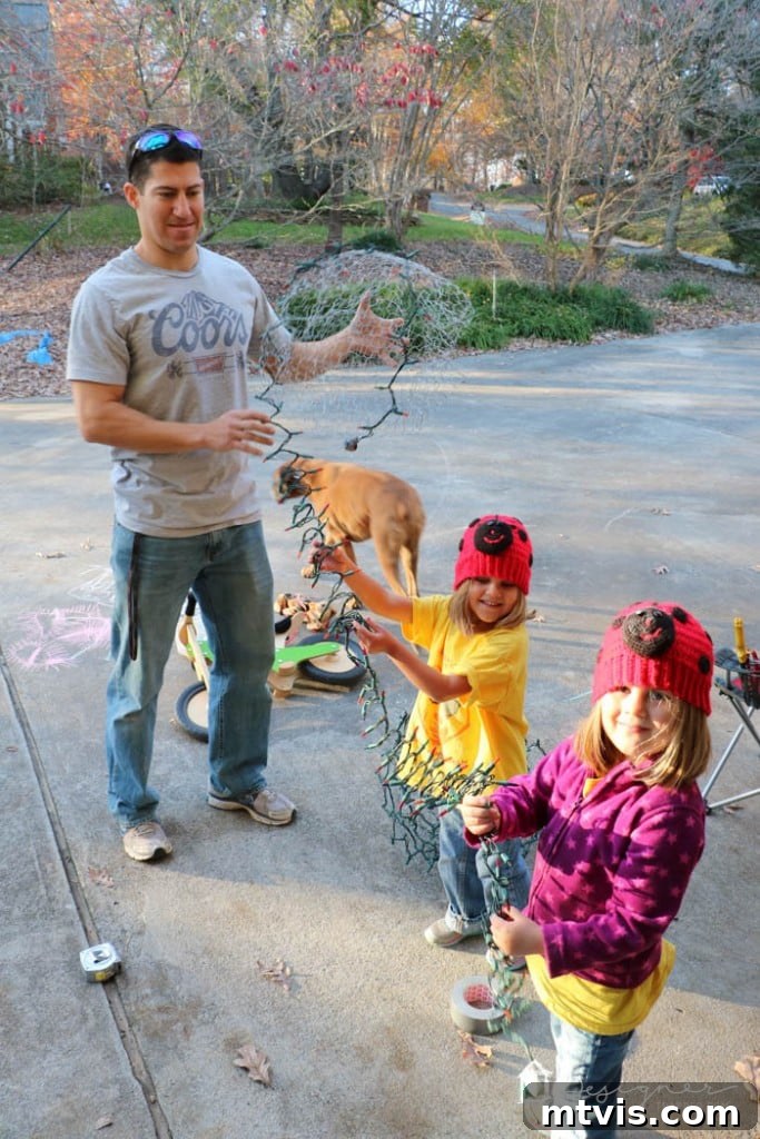 Family working together on lighted Christmas balls. Dad in a t-shirt, girls dressed by dad.