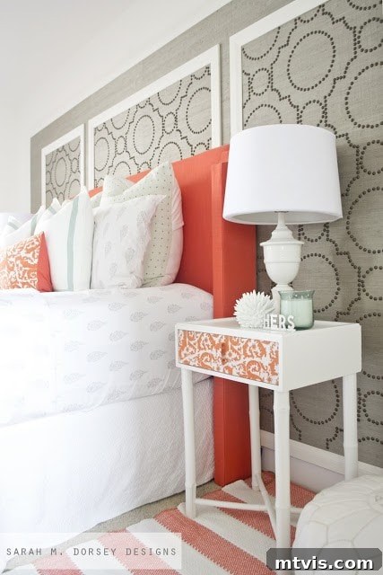 Elegant and colorful master bedroom by Sarah M. Dorsey Designs, featuring extensive DIY projects, a soothing palette with coral accents, and grass cloth texture.