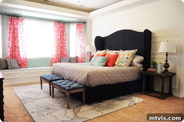 Vibrant master bedroom with a stunning DIY headboard and a navy and coral color scheme, showcasing creative budget decor.