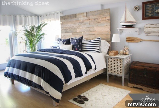 Sophisticated nautical themed master bedroom featuring a DIY reclaimed wood headboard and elegant coastal decor.