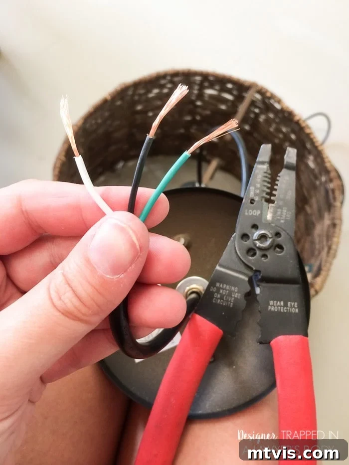 Light Up Your Space Effortlessly 5 Close-up of electrical wire being stripped to expose the copper strands, a necessary step for connecting a DIY pendant light.