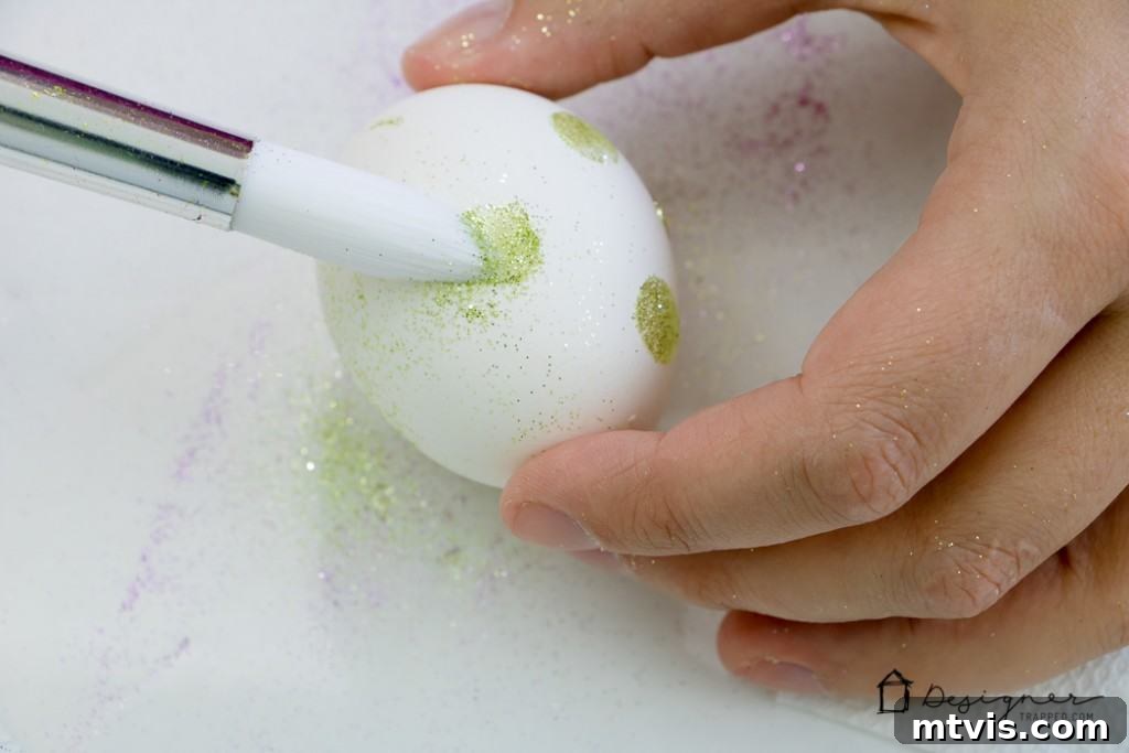 Sparkle and Spot: Creative Easter Egg Decorating 5 Close-up of glitter being applied to a glue dot on an Easter egg