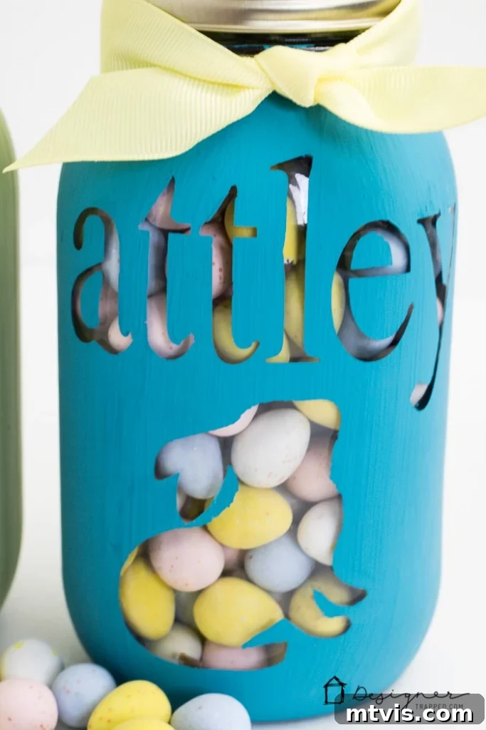 Craft Your Own Custom Mason Jars 7 Two personalized mason jars, one green and one blue, displaying custom names and holiday motifs, making them perfect bespoke gifts.