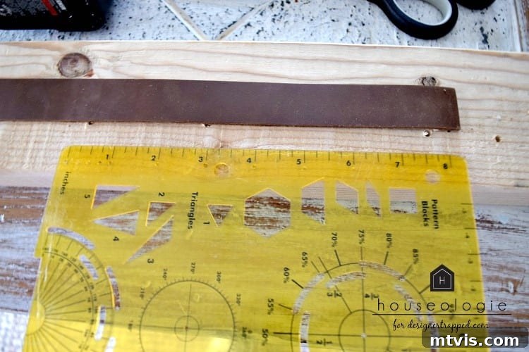 Close-up photo showing a ruler placed next to a strip of leather, illustrating the precise measurement required for crafting DIY leather drawer pulls.
