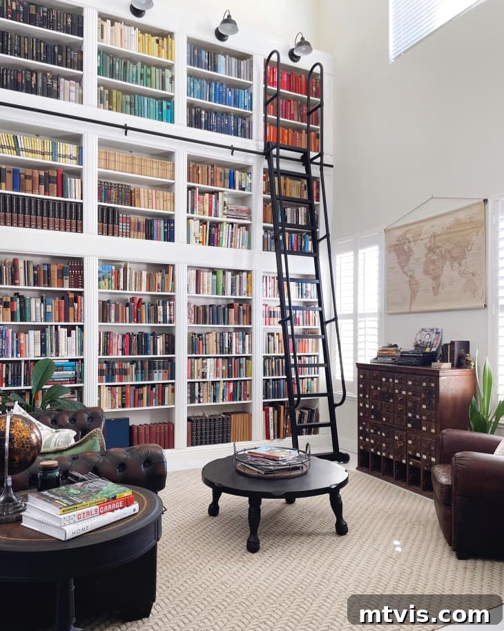 50 IKEA Hacks You Won't Believe Are IKEA 20 A sophisticated home library featuring plush leather chairs, a stylish round coffee table, and a striking wall map. The entire back wall is transformed by IKEA Billy bookcases, expertly converted into an impressive two-story bookshelf, complete with a functional black iron ladder on wheels.