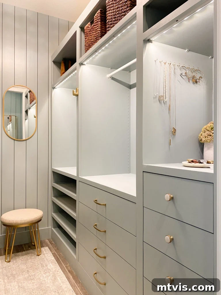 50 IKEA Hacks You Won't Believe Are IKEA 38 An elegant, angled view of customized sage green IKEA Pax units within a closet, featuring bespoke modifications. Delicate jewelry and practical wicker baskets are seamlessly integrated into the storage configuration. A small stool and a stylish mirror are positioned at the back, completing this chic and organized personal space.