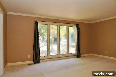 Playroom Paradise Unveiled 2 Initial view of a drab, beige formal living room before its transformation into a vibrant kids' playroom.