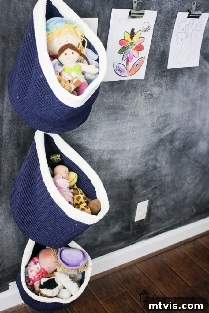 Playroom Paradise Unveiled 11 The DIY pipe shelving filled with books, creative supplies, and baskets for organized storage in the kids' playroom.