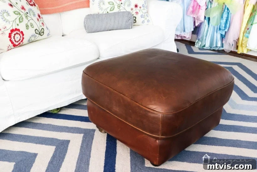 A wider shot showing the restored leather ottoman complementing the playroom's interior design.