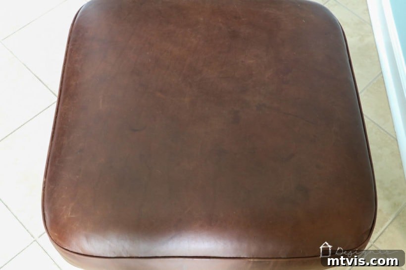 After restoration: The same leather ottoman looking significantly improved, with scratches and scuffs repaired.