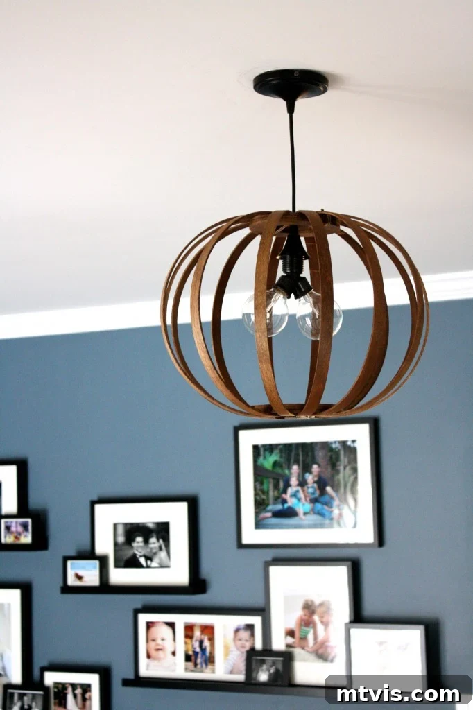 MUST PIN! Totally genius idea for making a DIY West Elm Bentwood Pendant Light. Full tutorial by Designer Trapped in a Lawyer's Body. Vertical shot of the DIY Bentwood Pendant Light hanging gracefully, highlighting its unique silhouette.
