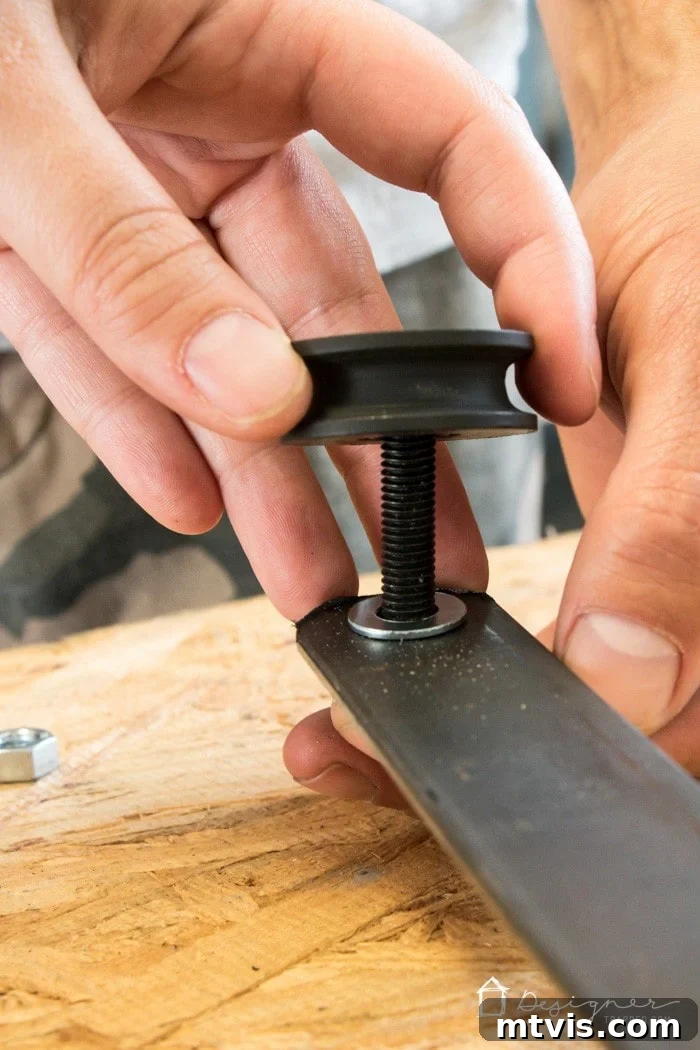 Attaching pulley wheel to the wheel post of the fireplace screen