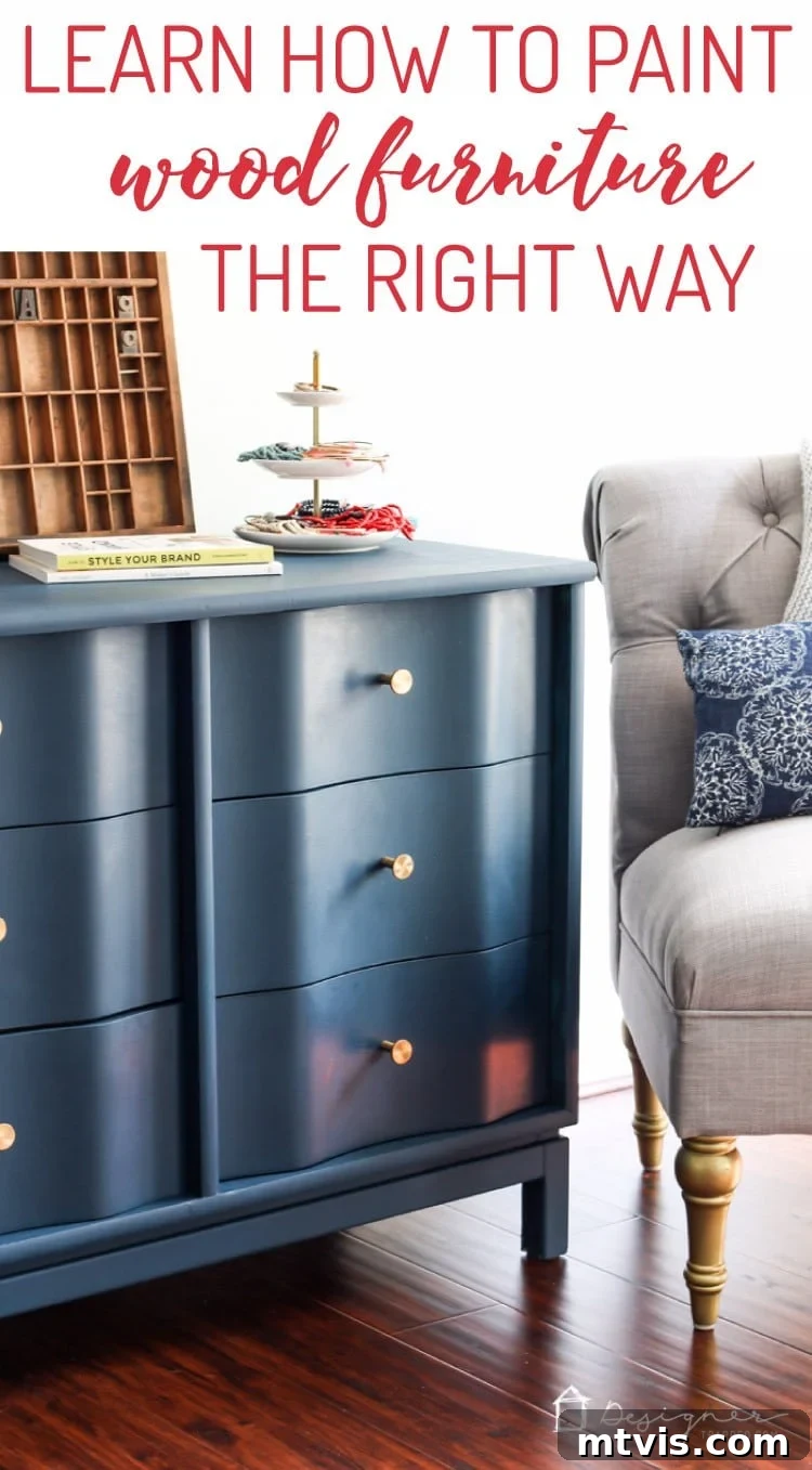 A long graphic displaying a beautifully painted blue dresser with a wavy front and gold hardware, positioned alongside a comfortable grey tufted chair. The text in the lower right-hand corner reads, "DesignerTrapped.com," while the prominent text above advises, "Learn How to Paint Wood Furniture the Right Way."