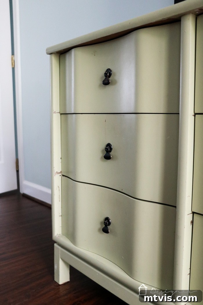 A close-up view of a vintage three-drawer dresser showing extensive chipping and peeling latex paint. This visual evidence highlights the common issues arising from incorrect paint choices when learning how to paint wooden furniture.