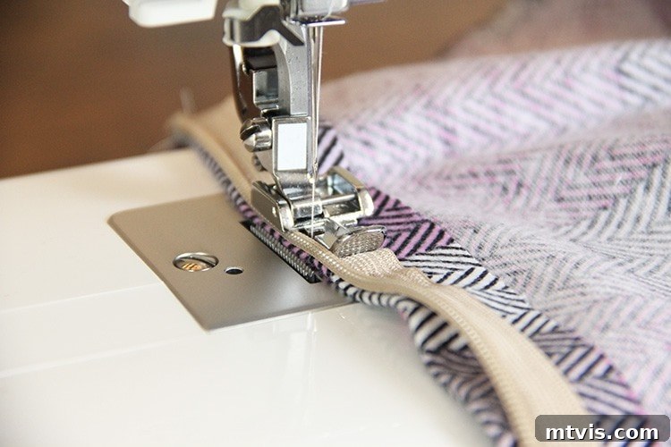 Sewing a Zippered Pillow Cover 12 Sewing machine stitching the second side of the zipper, with the fabric securely pinned.