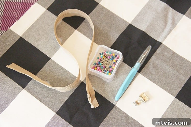 Sewing a Zippered Pillow Cover 3 Arrangement of a zipper, two coordinating fabrics, and straight pins, ready for a DIY pillow cover project.