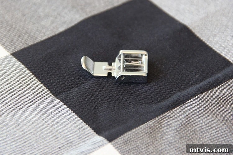 Sewing a Zippered Pillow Cover 7 Close-up of a zipper foot attachment on a sewing machine, ready for use.