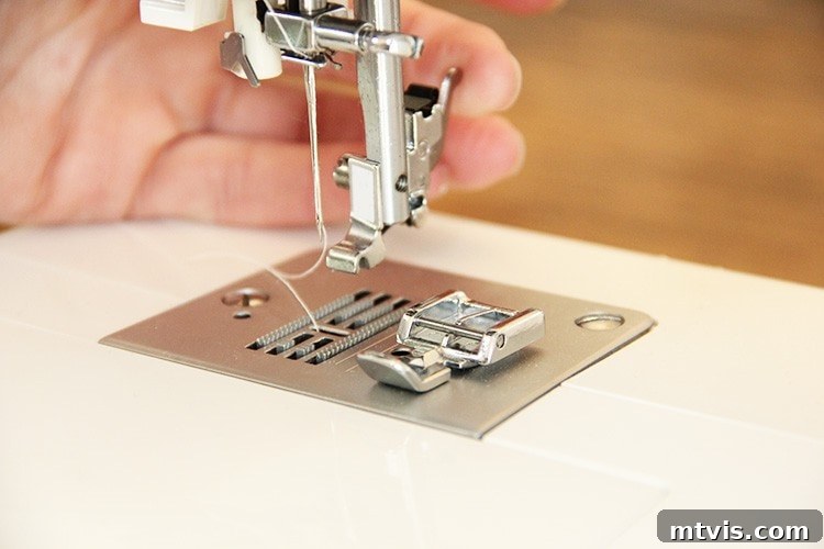 Sewing a Zippered Pillow Cover 8 A zipper foot being attached to a sewing machine, demonstrating how it hooks into place.