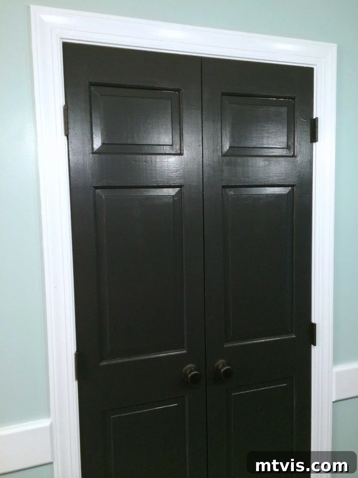 DIY Drama Black Doors White Trim 4 Pantry doors have been updated with a fresh coat of black paint, white trim and mint green walls.