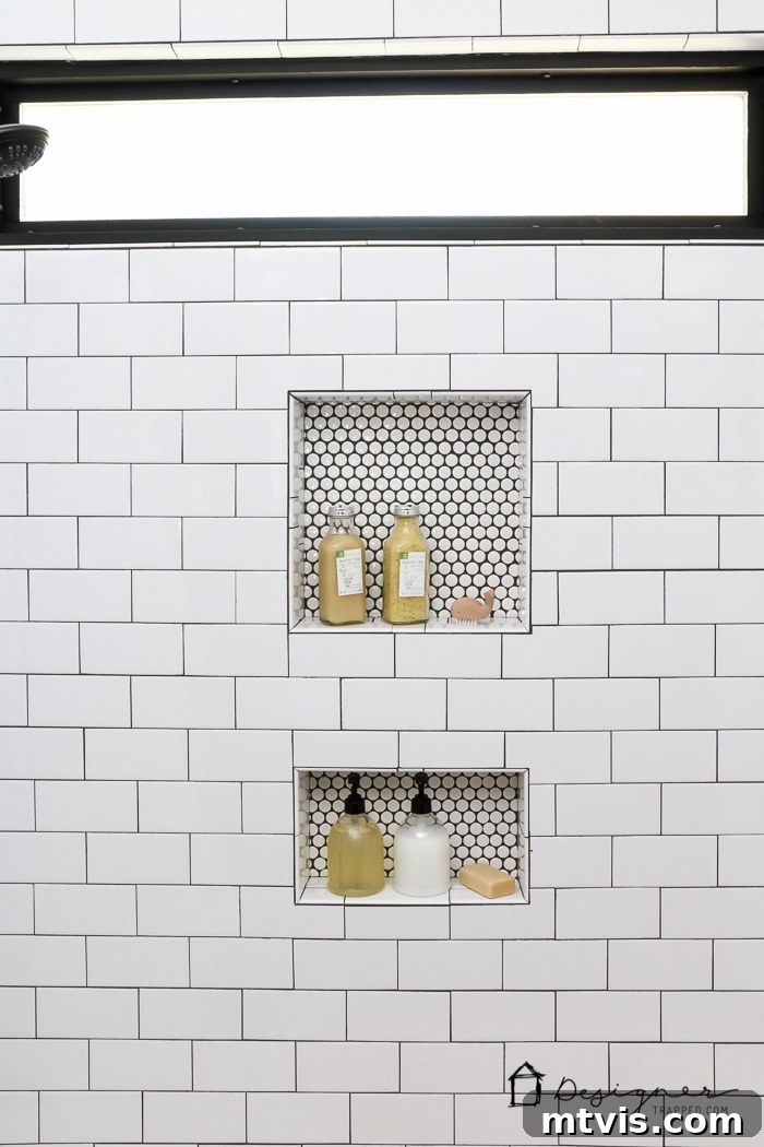 The shower area reveals striking penny tile in niches and a bold black-painted window frame, showcasing innovative design choices in a DIY bathroom remodel.