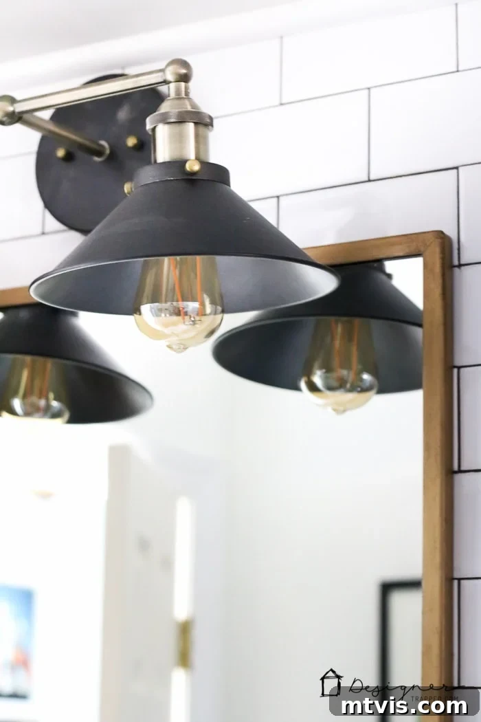 The stunning and budget-friendly vanity lights, a favorite feature of the DIY bathroom remodel, illuminate the space with style and efficiency.