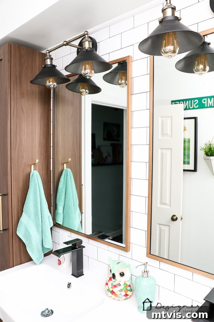 Another perspective of the vanity lights and mirror, showcasing their impactful design and how they contribute to the modern aesthetic of this DIY bathroom remodel.