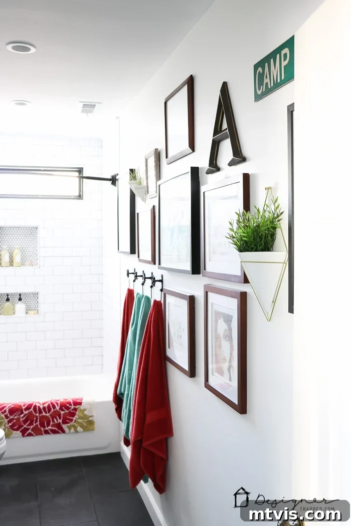 Close-up of the charming gallery wall, showcasing a mix of original art and inexpensive prints framed, complemented by modern wall vases in the DIY bathroom remodel.