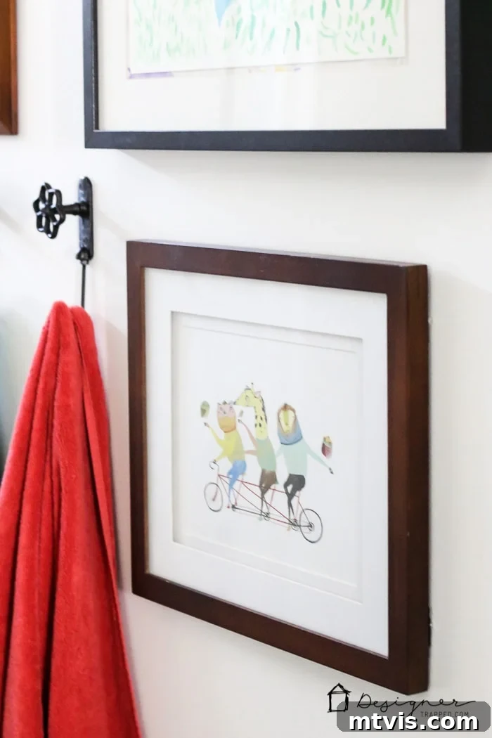 Another detail of the carefully curated gallery wall, demonstrating how personal touches and budget art can create a unique and inviting atmosphere in a DIY bathroom.