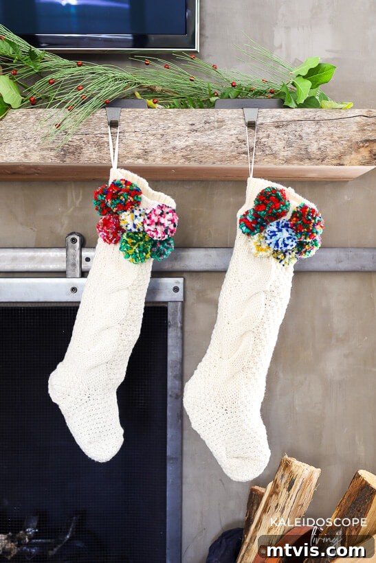 Craft Your Own Christmas Stockings 3 Close-up of a handmade DIY pompom Christmas stocking, showing colorful yarn pompoms attached to a cream knitted stocking, hanging in a festive setting.
