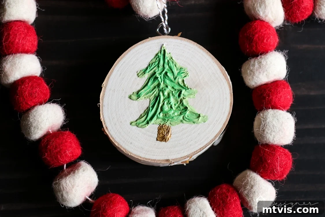 Create Stunning Textured Holiday Decor 12 Close-up of a handmade textured Christmas ornament, highlighting the rustic charm of the wood slice and the detailed caulk texture.