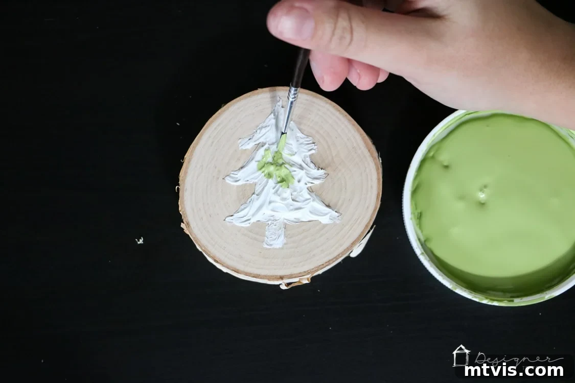 Create Stunning Textured Holiday Decor 7 Painting the dried caulk Christmas tree ornament with green paint for the foliage and gold for the trunk.