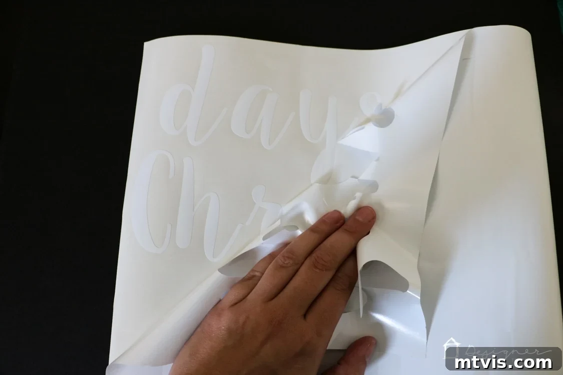 Handcrafted Christmas Countdown 7 Close-up of a hand meticulously weeding excess vinyl from a detailed design.