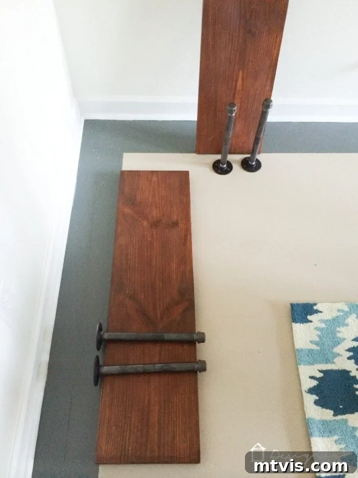 Your Ultimate Guide To Effortless Pipe Shelves 4 Installing the first assembled pipe bracket onto the wall