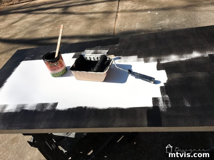 Painting a prepared hollow core door in black to achieve a modern industrial look for the DIY desk.