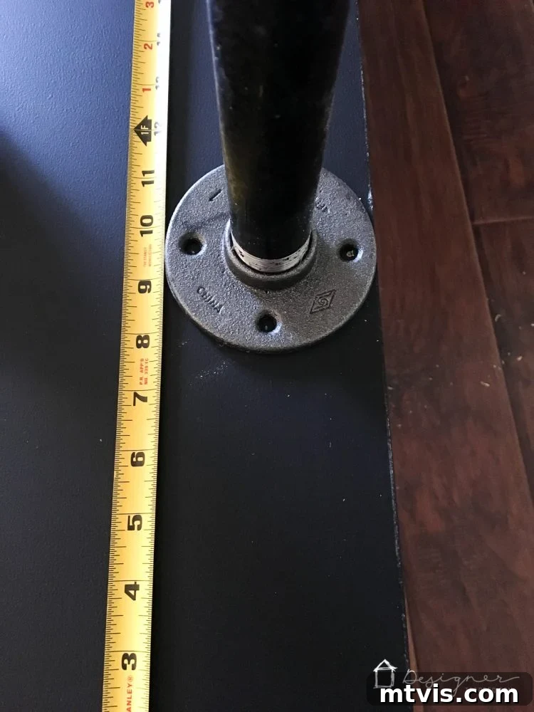 Measuring and precisely positioning floor flanges on the underside of a hollow core door desk prior to permanent attachment.