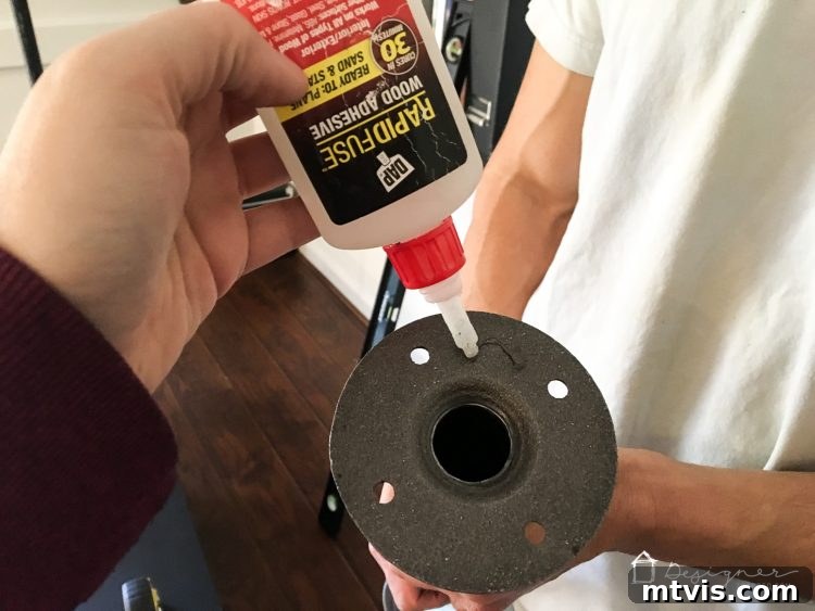 Applying DAP Rapid Fuse all-purpose adhesive to the back of a floor flange for a super strong bond to the hollow core door.