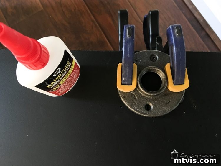 Floor flanges securely clamped to the underside of the DIY pipe desk, allowing DAP Rapid Fuse to set for a strong attachment.