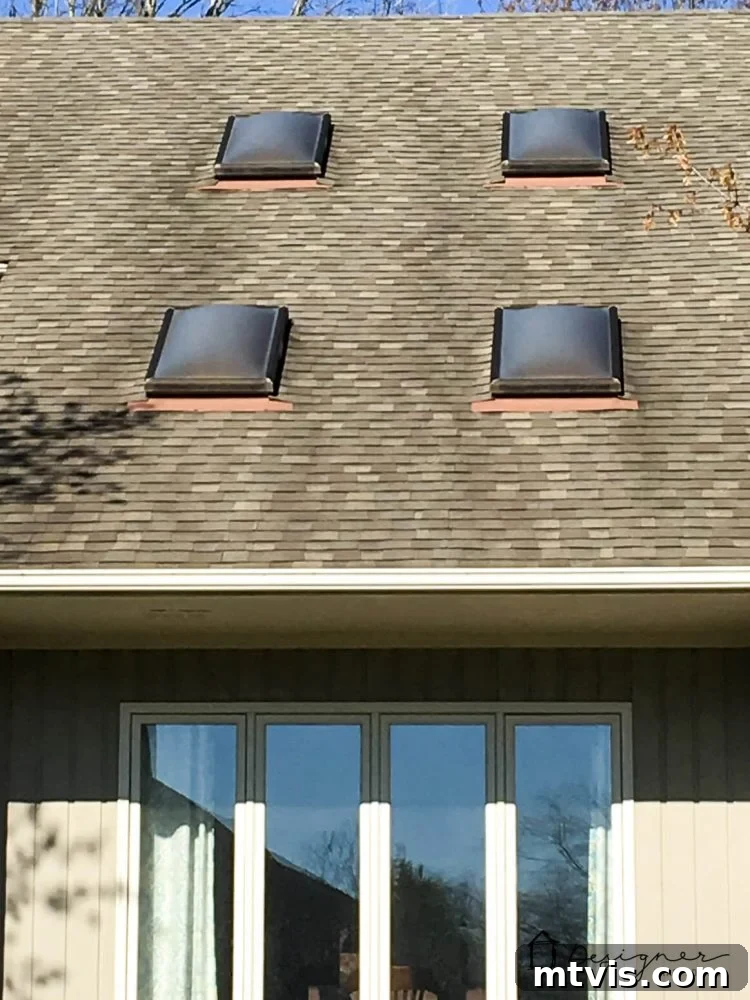 A clear view of a VELUX skylight from below, showing the blue sky and cloud through its pane.