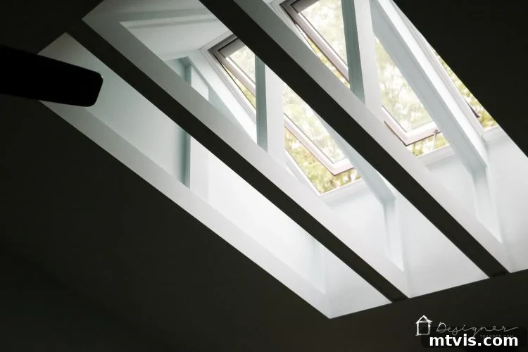 Brightly lit interior scene with multiple VELUX skylights open, revealing clear skies and adding architectural detail.