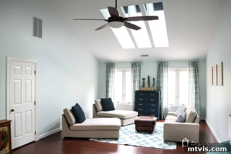 A serene bedroom setting with two VELUX skylights illuminating a sitting area, showcasing elegant interior design.