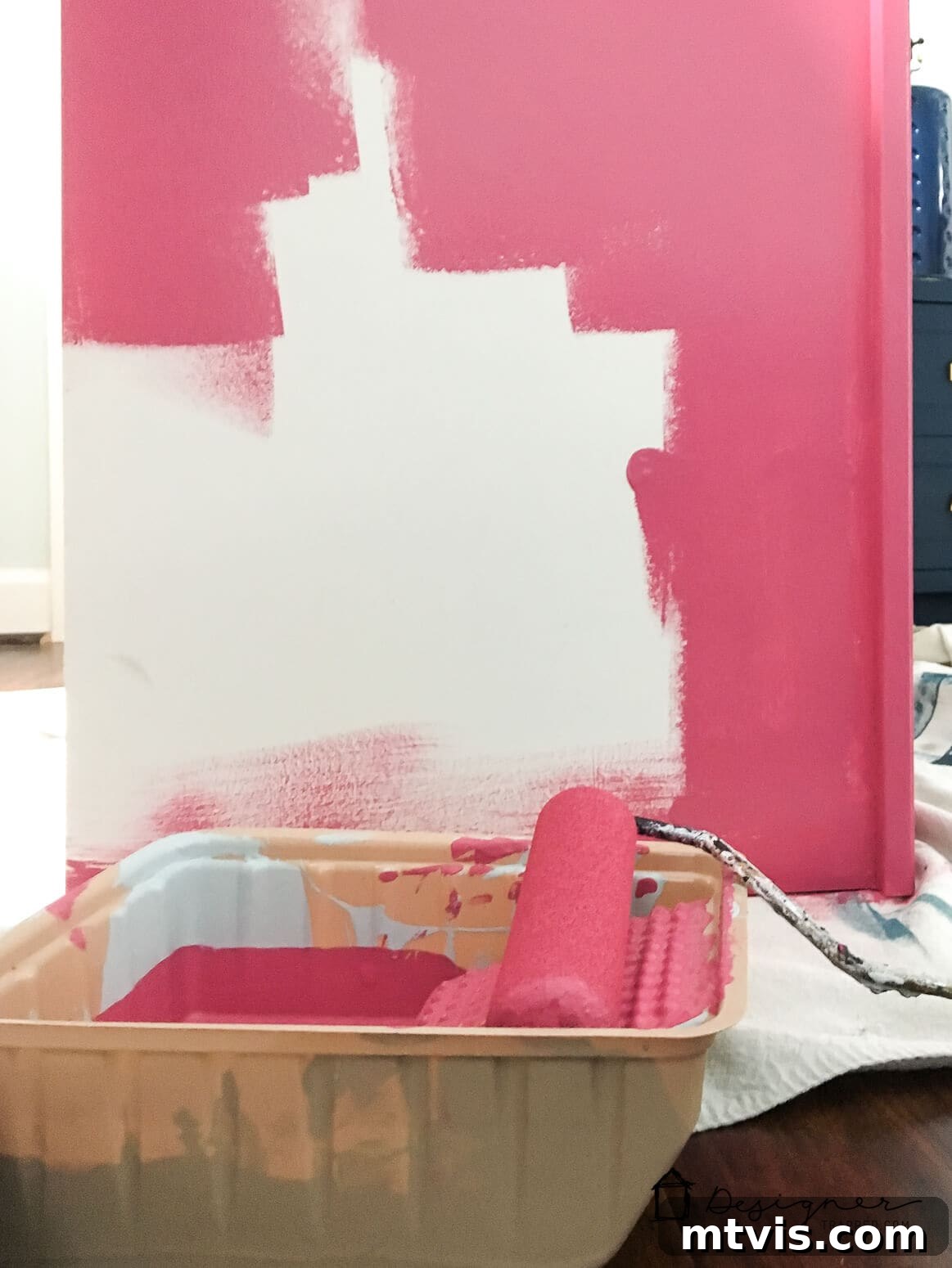 Billy Bookcase Brilliance: IKEA Hacks for Ultimate Storage 3 Halfway through painting, a white IKEA Billy bookcase begins to transform with a vibrant pink hue.