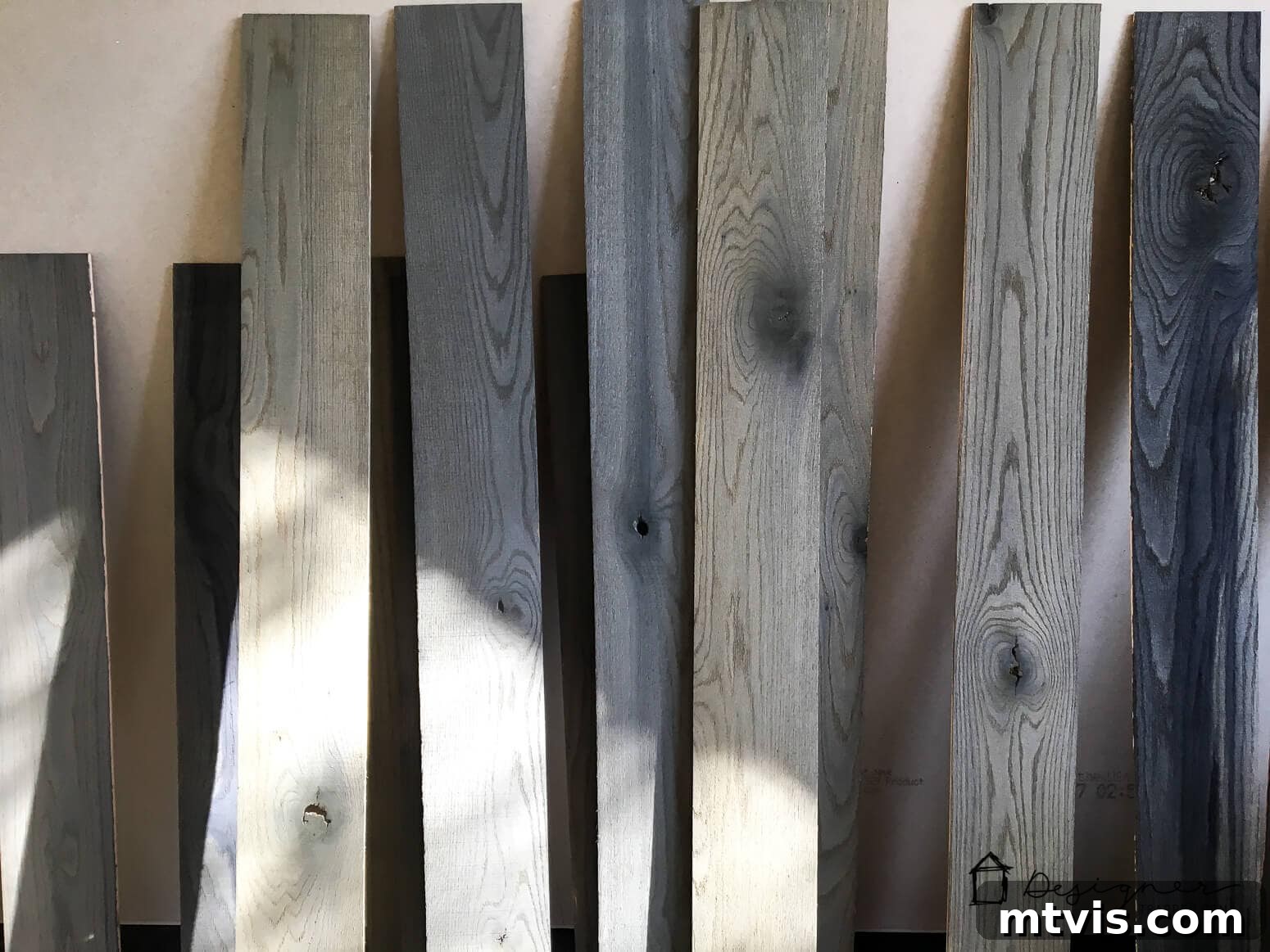 Billy Bookcase Brilliance: IKEA Hacks for Ultimate Storage 5 Treated wood planks are stacked against a wall, ready to be installed as the custom backer for the IKEA Billy bookcase hack.