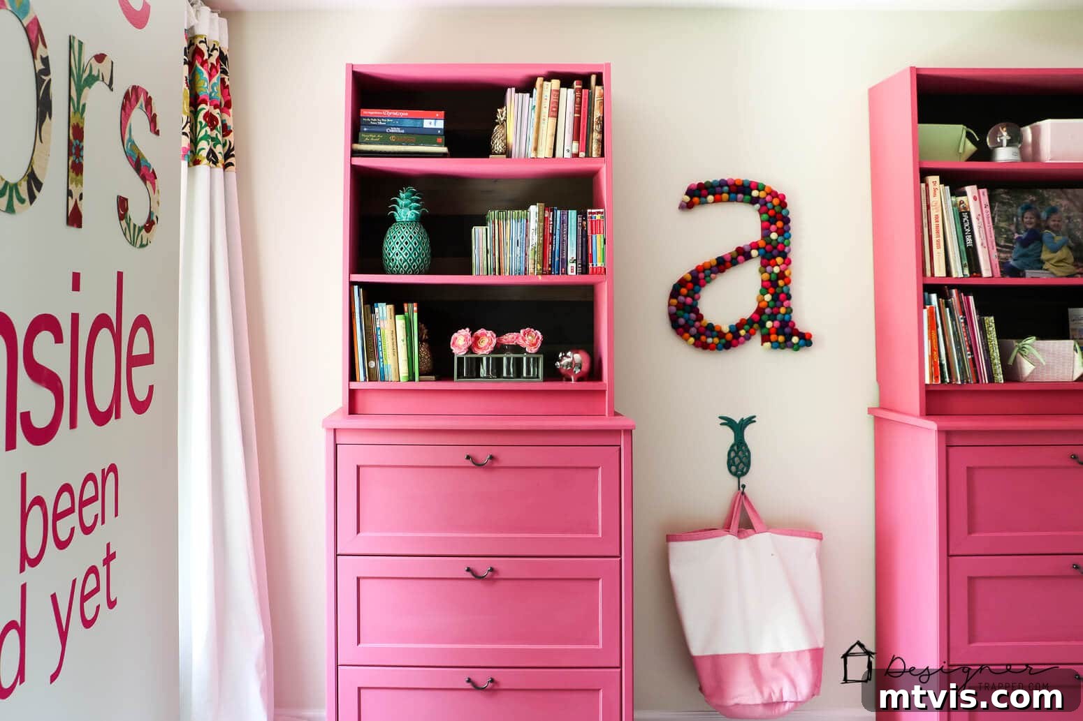 Billy Bookcase Brilliance: IKEA Hacks for Ultimate Storage 9 The finished IKEA Billy bookcase hack in a girl's room, featuring pink dressers topped with bookshelves and a vibrant felt-ball letter 'A' on the wall.