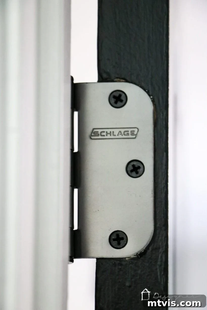 Repairing a Door That Won't Shut 4 Close-up of an oil-rubbed bronze hinge on a black interior door, highlighting hinge details