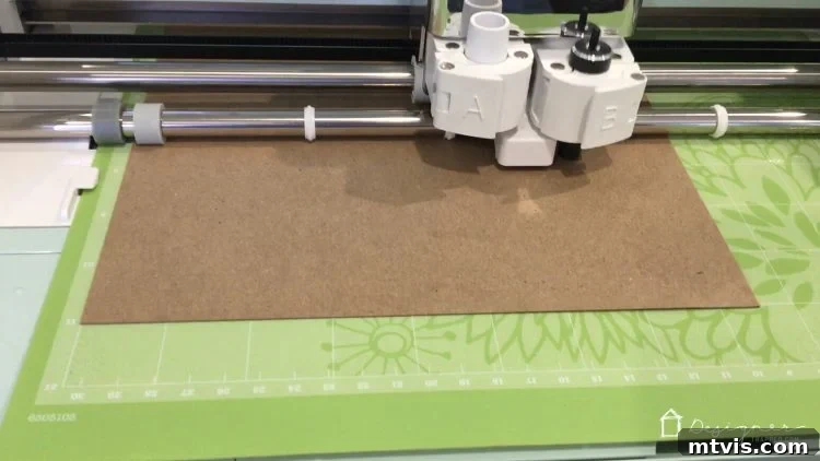 Cricut machine precisely cutting chipboard letters for the fabric-covered portion of the DIY wall quote.