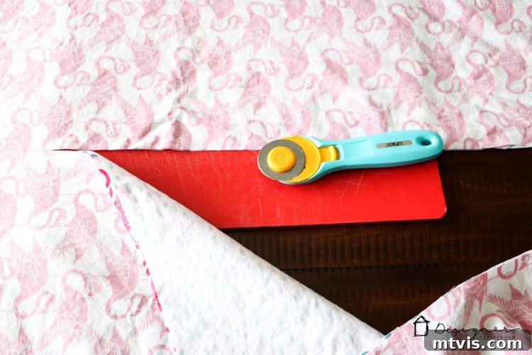 Transform Your Bed with a Flat Sheet Canopy 4 Using a rotary cutter to make a precise, straight cut on stacked sheets for the bed canopy.