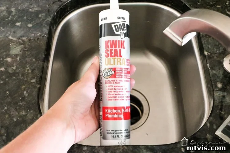 A hand applying a fresh bead of DAP Kwik Seal Ultra caulk around a cleaned sink joint using a caulk gun. Applying new caulk.