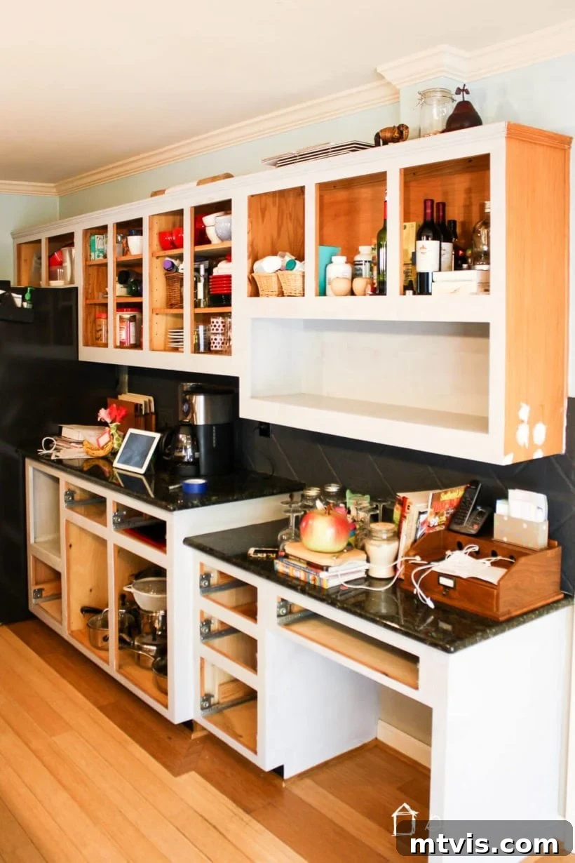 Is Painting Your Kitchen Cabinets Right for You? Essential Questions Before You Begin 7 Interior of a kitchen during cabinet painting, showcasing protective coverings and removed doors.
